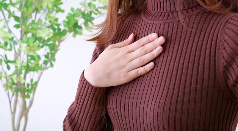 胸に手を当てる女性