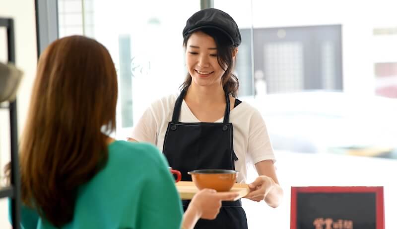 配膳をする女性店員