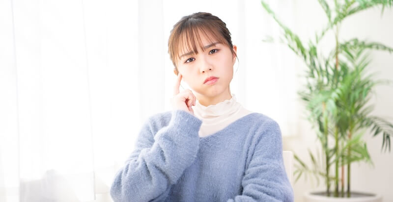 考え事をしている若い女性