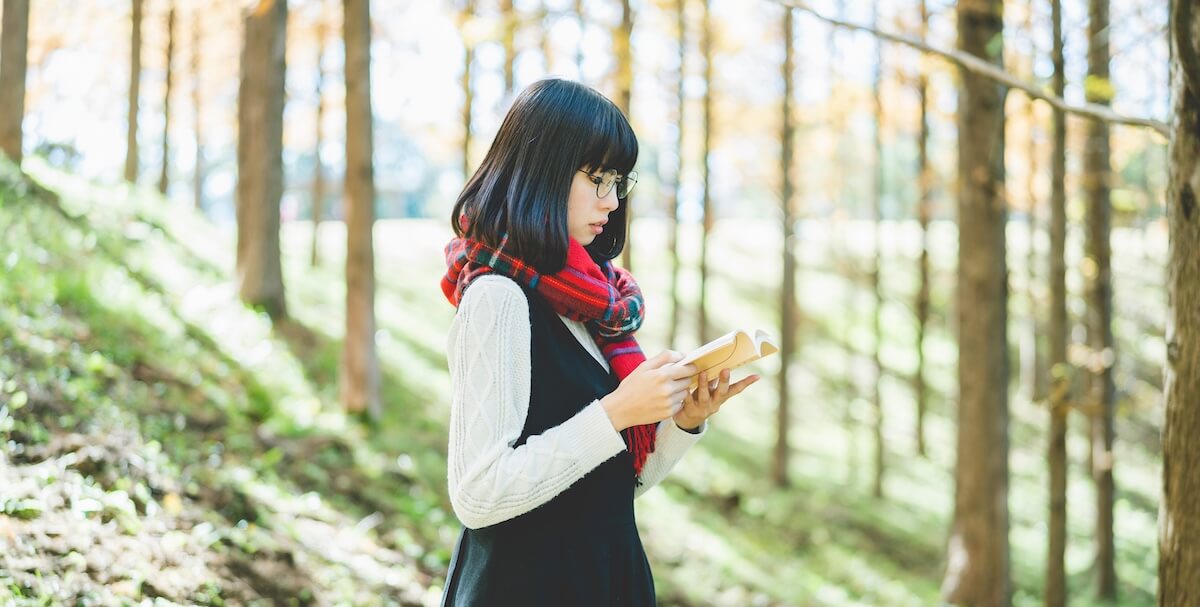 森で読書をする女性